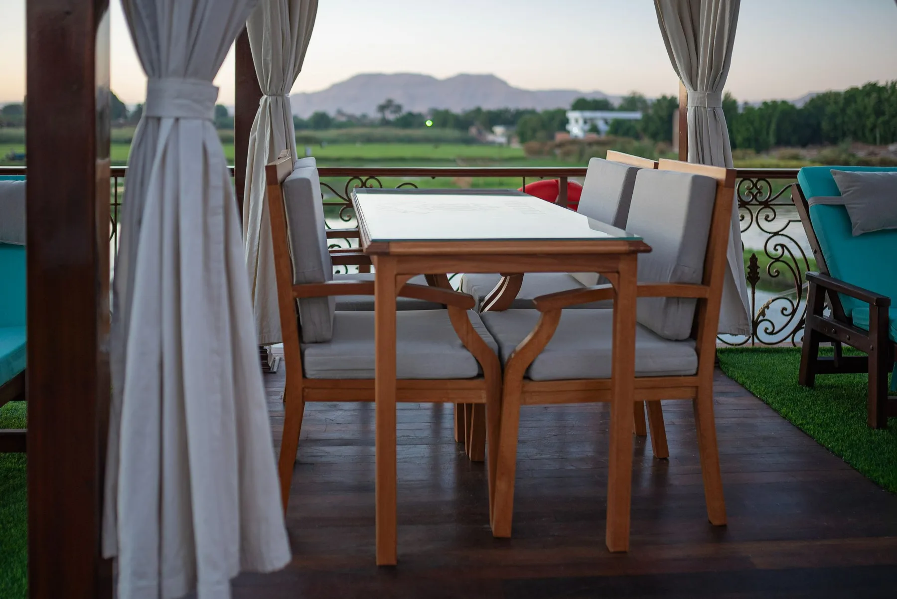 Farida dahabiya deck dining table with Theban hills view