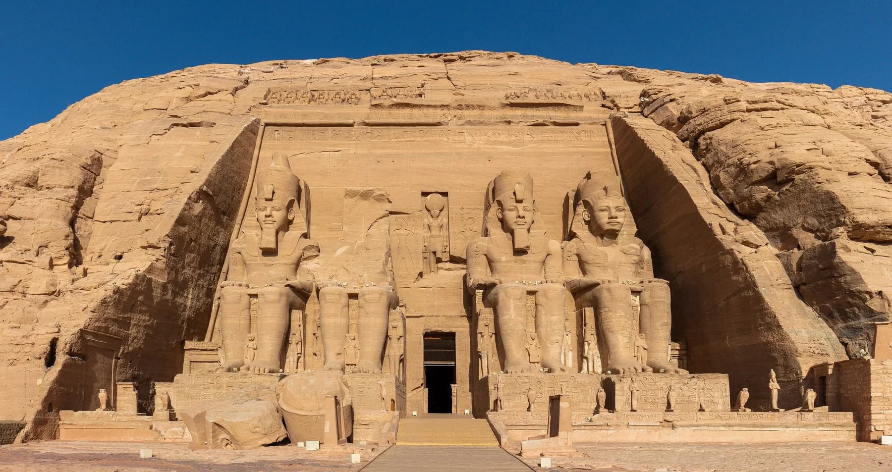 Facade of the Great Temple of Ramesses II with its four seated colossi under a clear blue sky