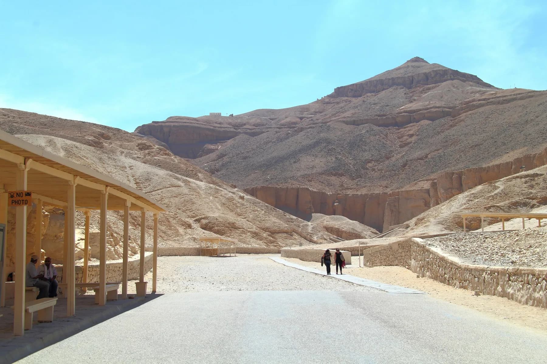 Main path into the Valley of the Kings with shade shelter and the pyramid-shaped peak of el-Qurn behind