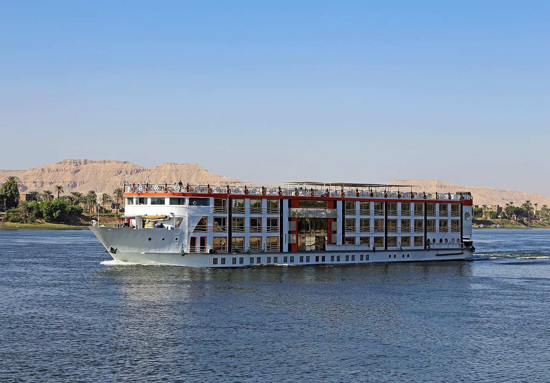 Cruise ship under way with Theban hills behind