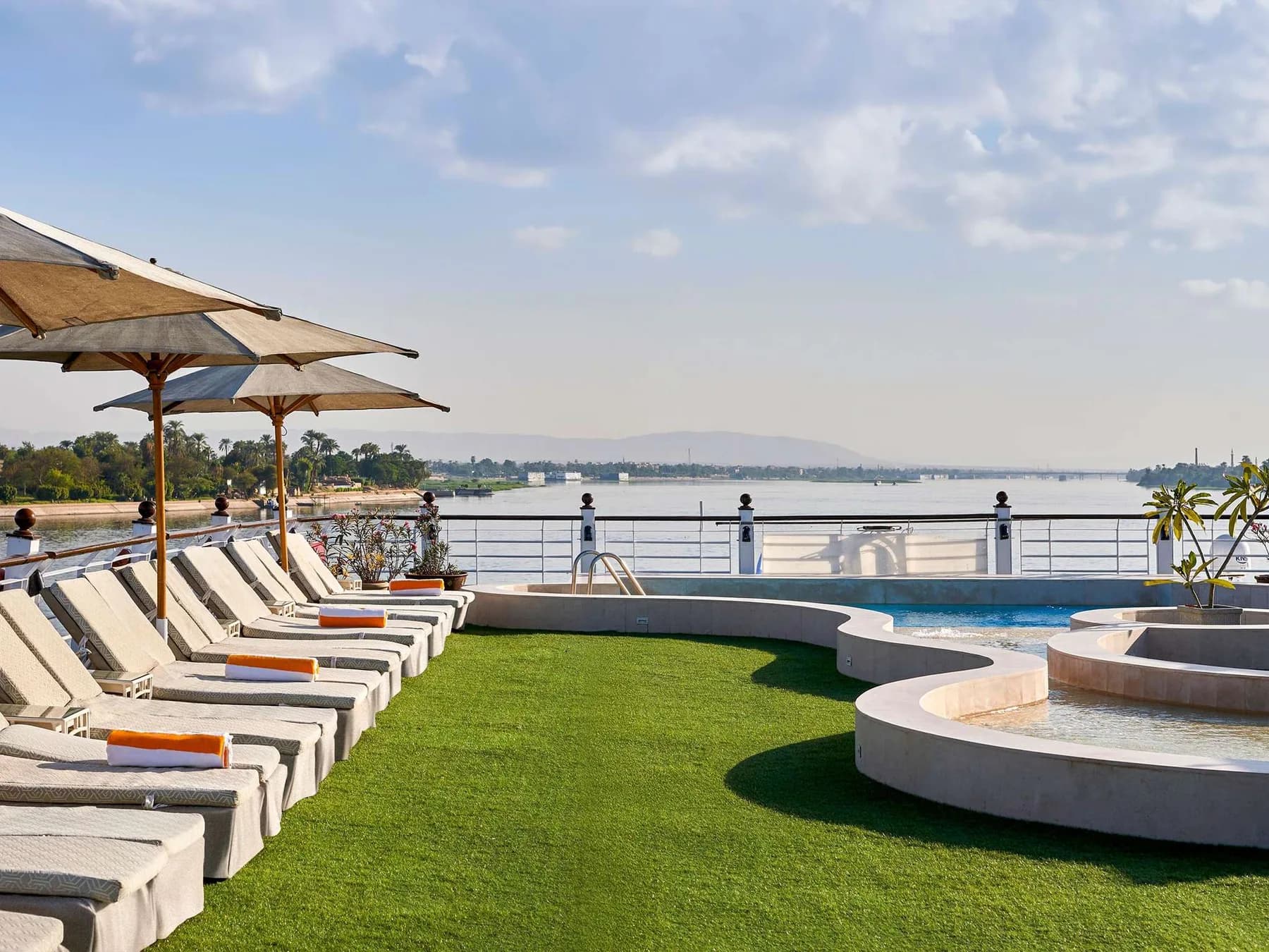 Sun deck with loungers, parasols and pool