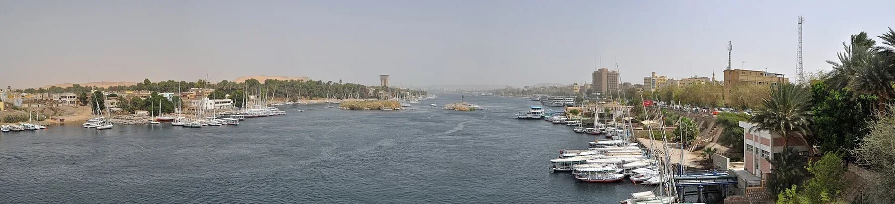 Aswan riverfront panorama with feluccas and moored cruise ships