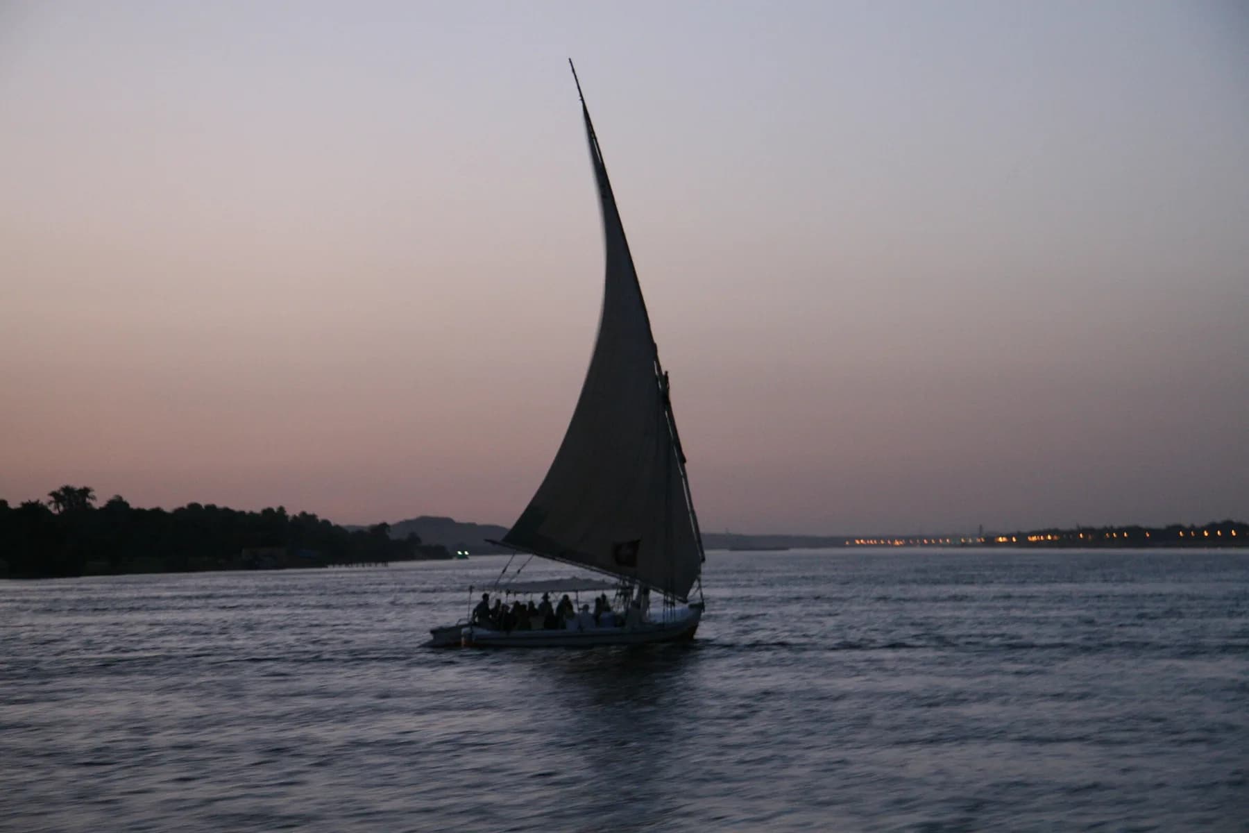 Felucca under sail at Aswan at dusk, pink sky