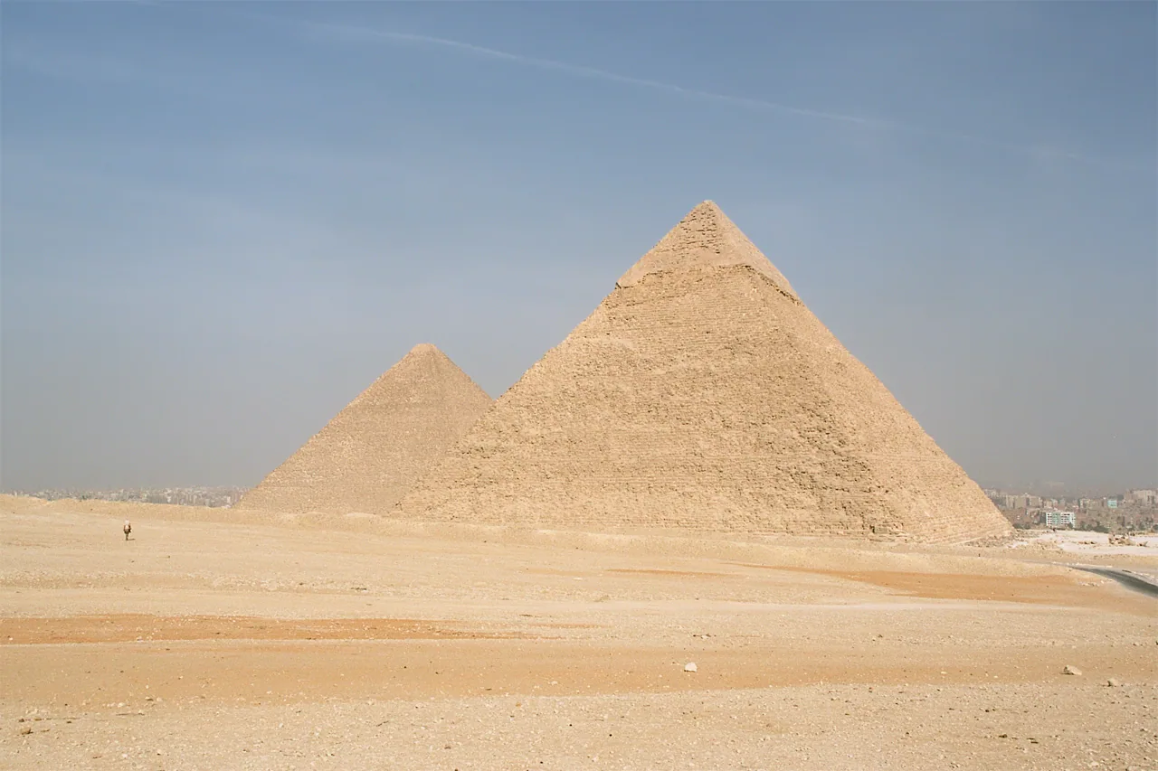 Two of the Giza pyramids rising above the open desert of the plateau