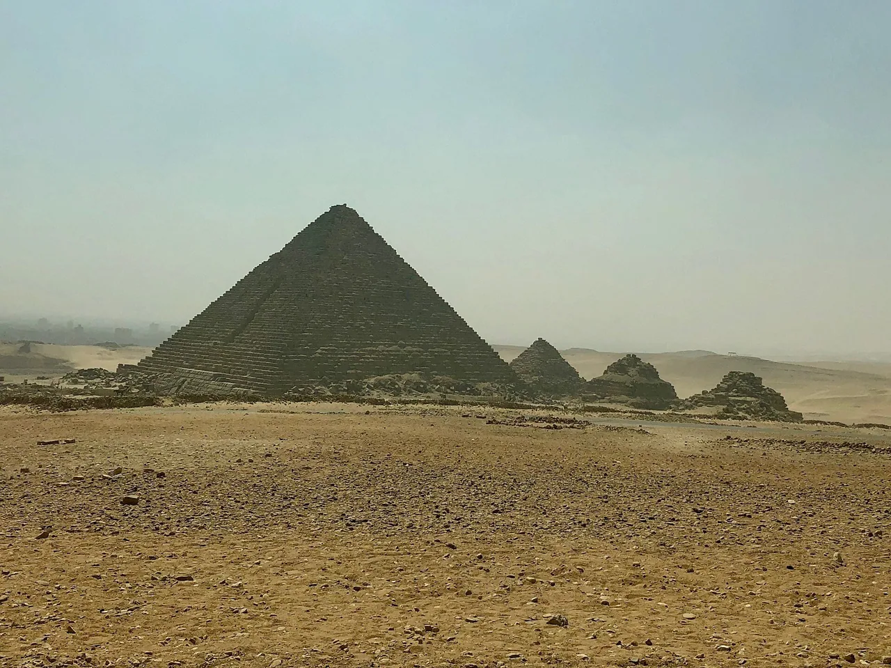 Menkaure's pyramid with its three small queens' pyramids on a hazy day