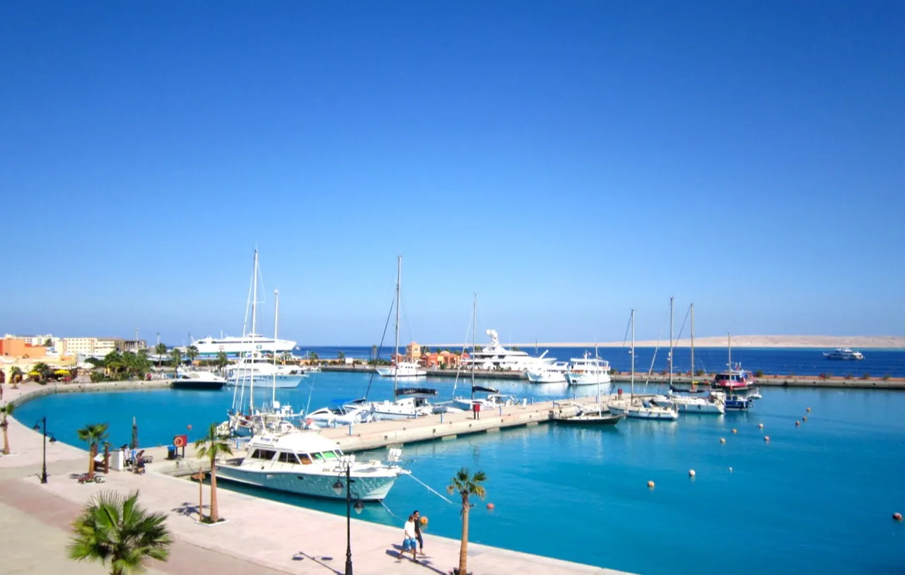 Hurghada Marina basin by day, yachts at the pontoons and the promenade curving round the water